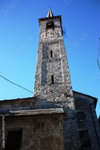 Bell tower of Chiesa di Maria Vergine Assunta under blue sky in Mergozzo, Italy photo