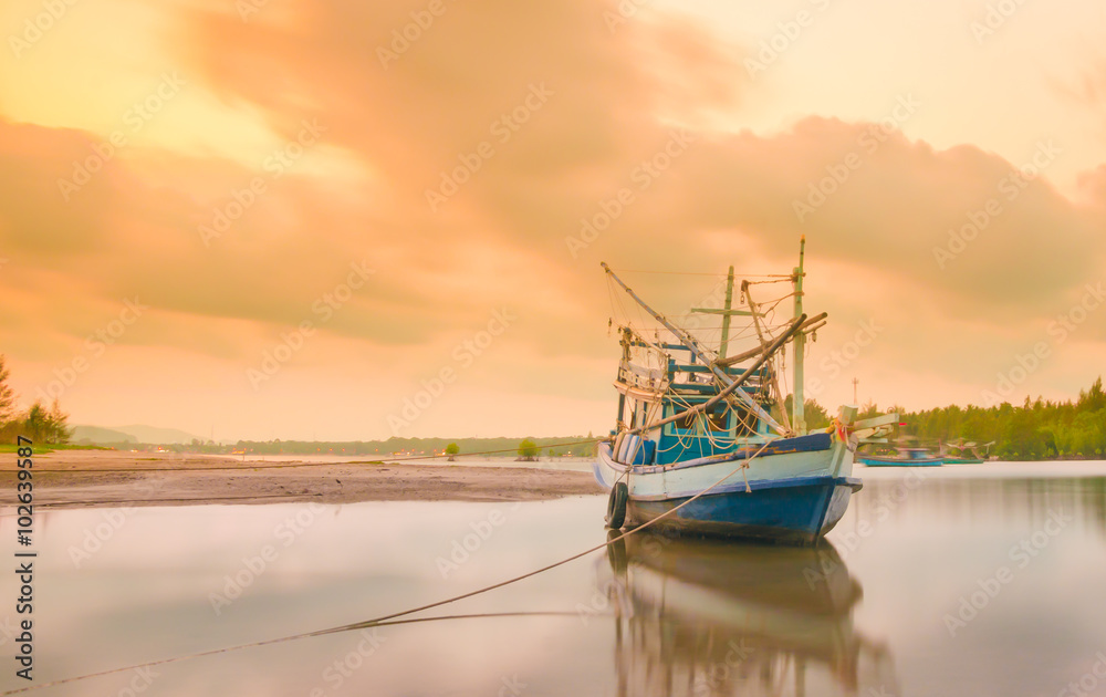 Naklejka premium Fishing boat stops near bay at sunset time in Thailand