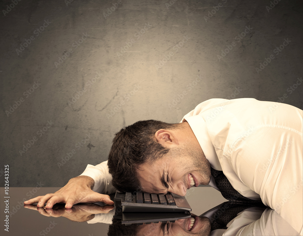 Obraz premium Frustrated businessman's head on keyboard