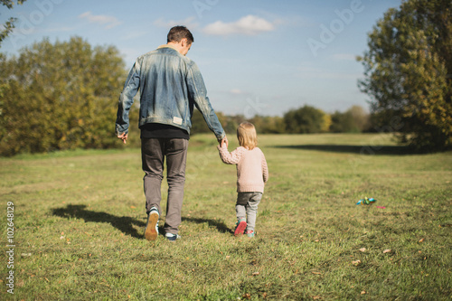 father and daughter walking in park