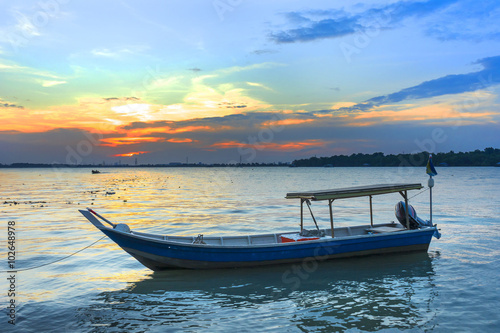 Wooden fisherman boat with sunset background