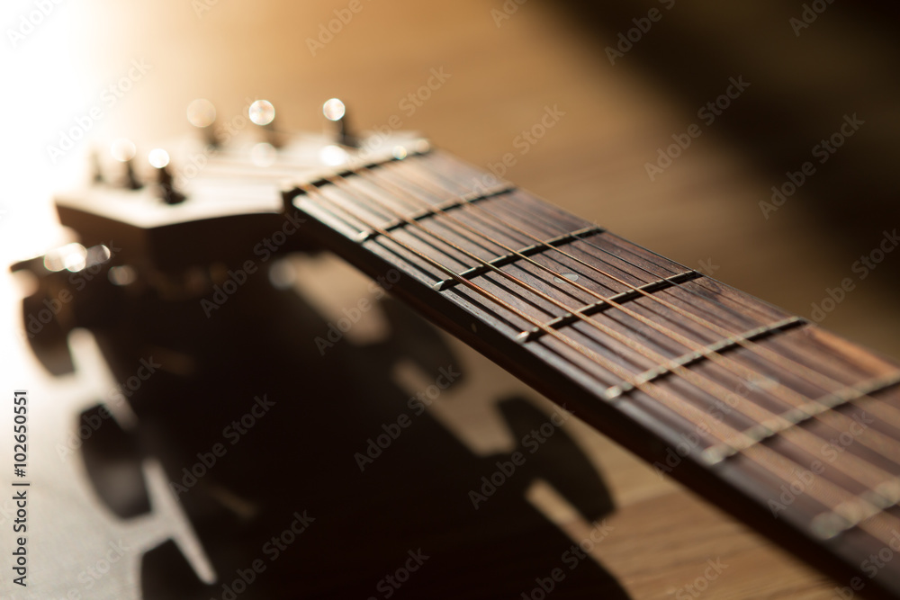 Fototapeta premium guitar neck with string on blurred wood background light and sha