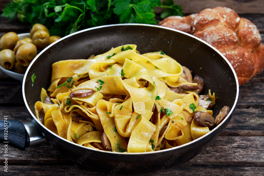 Pappardelle Pasta with mushrooms and other herbs. in wok.