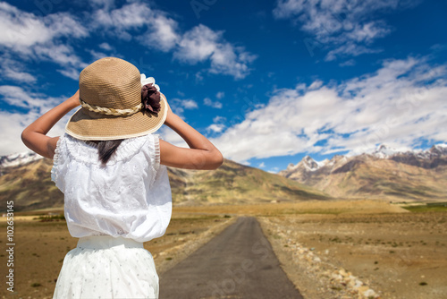 Back of traveller girl with a road to Zanskar Valley in sunny da photo