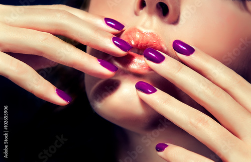 Beautiful model shows purple manicure on nails.  .Luxury fashion style, manicure nail , cosmetics and makeup . 
