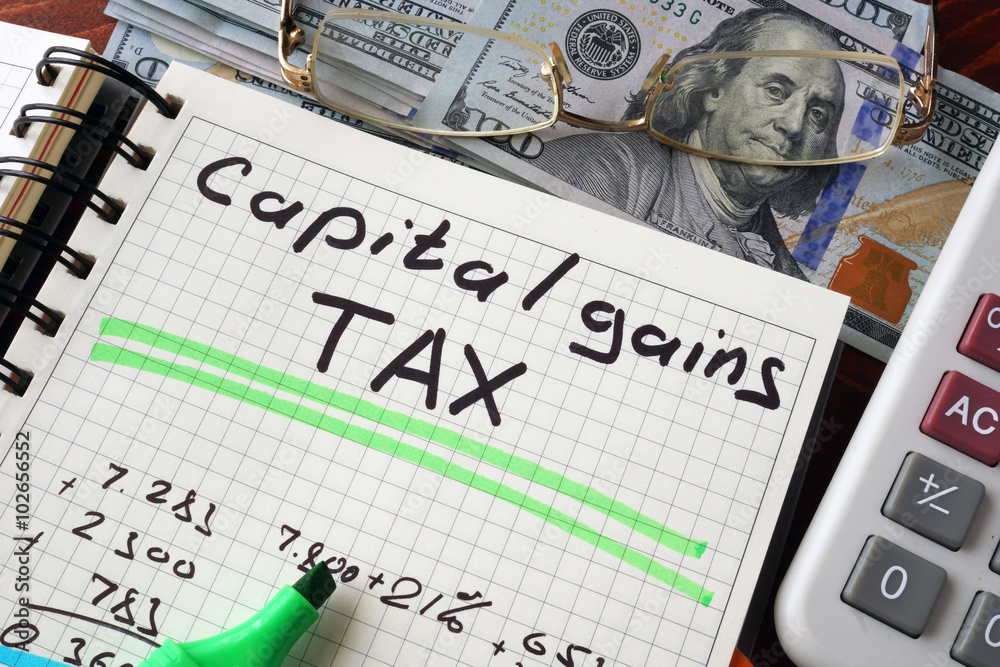 Notebook with capital gains tax  sign on a table. Business concept. - obrazy, fototapety, plakaty 
