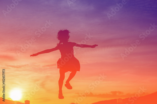 Girl jumping during sun set, colour filter effect.