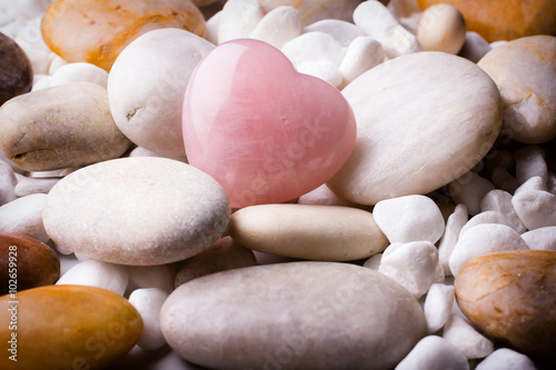 Pink heart stone on the spa stone background.
