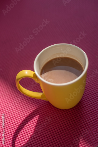 Gourmet Hot Chocolate Milk in yellow cup on pink yoga mat with w
