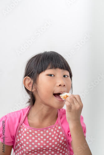 Asian girl eating bread at home.
