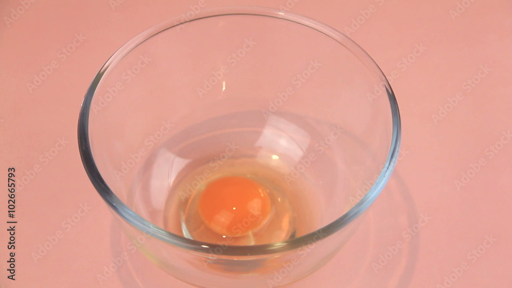 Cracking two eggs into a bowl and whisking briskly.