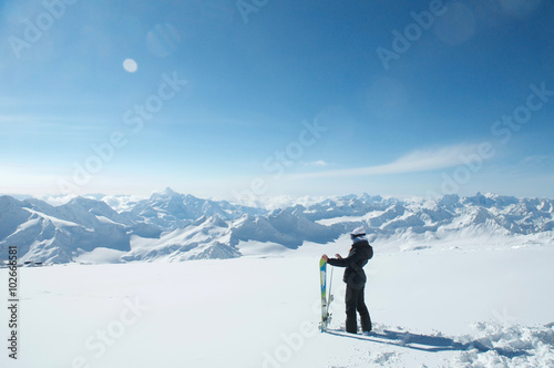 Side view of skier looking at snow covered mountains.