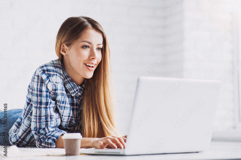 Young beautiful woman using a laptop computer at home Young beautiful woman using a laptop computer at home