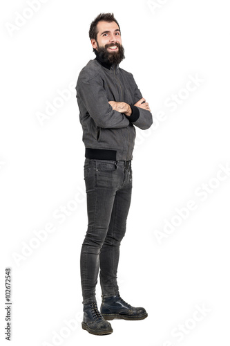 Funny laughing bearded man in tight jeans and army boots looking at camera. Full body length portrait isolated over white studio background.  © sharplaninac