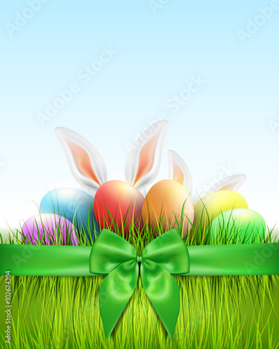 Easter background with eggs in grass and green ribbon.