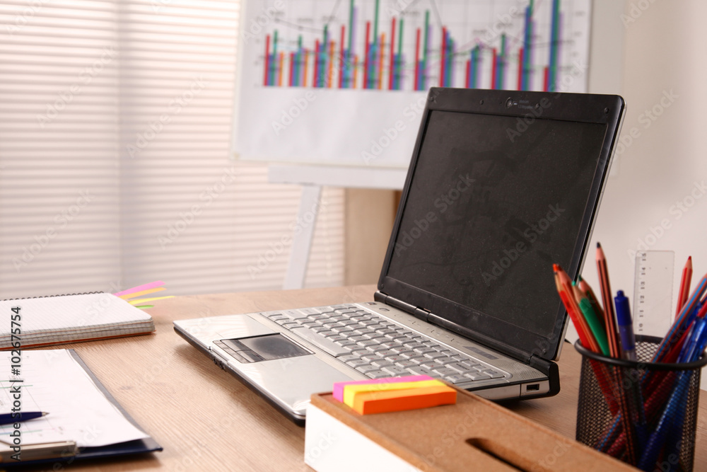 Office table with blank notepad and laptop Office table with blank notepad and laptop