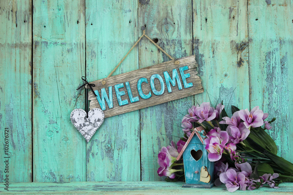 Φωτογραφία Welcome sign with heart hanging over birdhouse and spring flowers