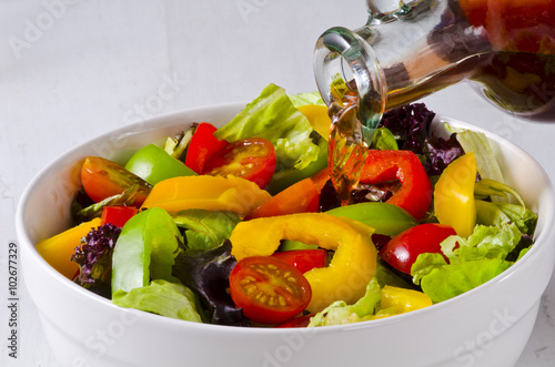 Vinegar pouring into salad bowl
