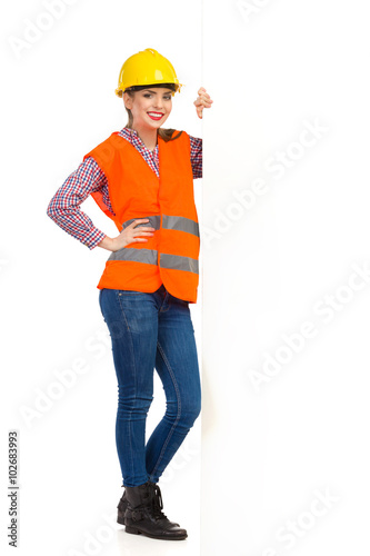 Smiling Female Construction Worker Standing Close To White Banner