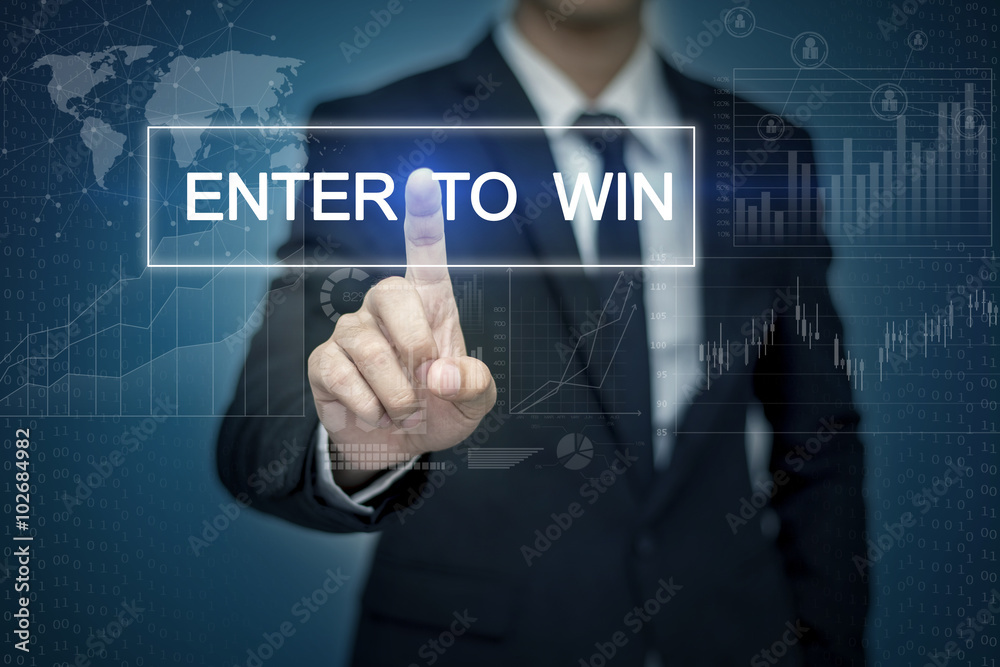 Businessman hand touching ENTER TO WIN button on virtual screen Businessman hand touching ENTER TO WIN button on virtual screen