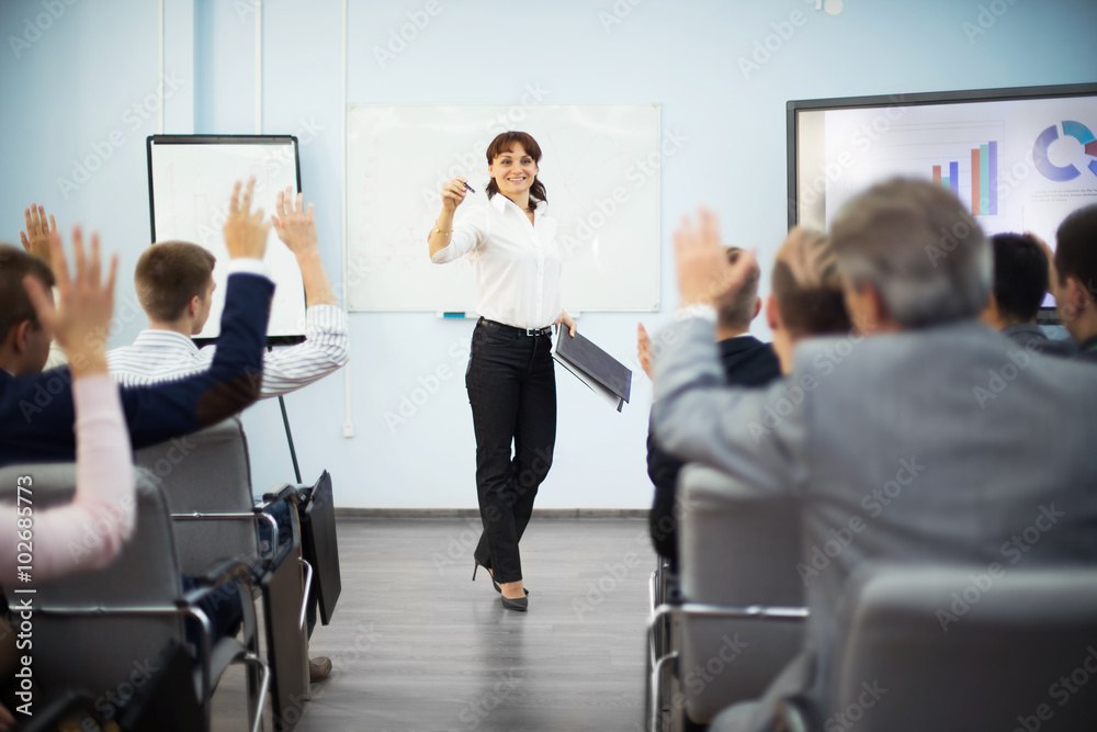 students raising hands to ask question during seminar
