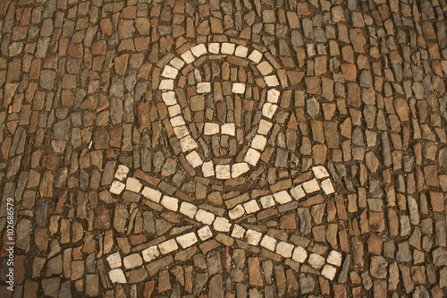 Symbol of crossed bones and skull created from white cobbles on the ground. Taken in Sedlec, Kutna Hora ossuary, Czech Republic
