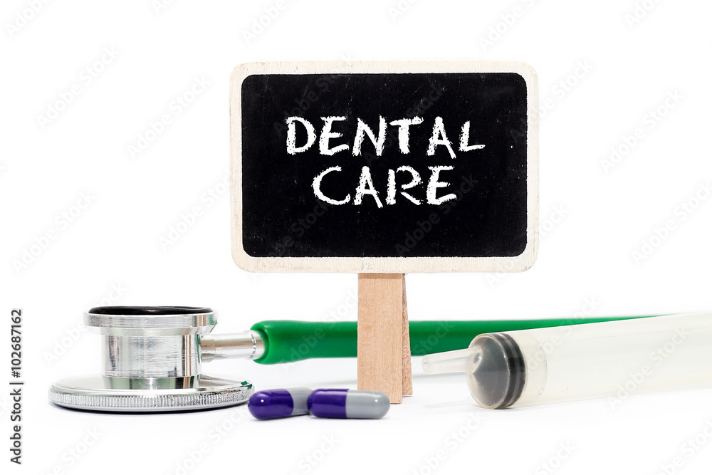 DENTAL CARE concept with text on chalkboard with stethoscope, syringe and pills