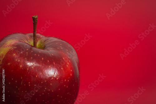 Red apple on the red background