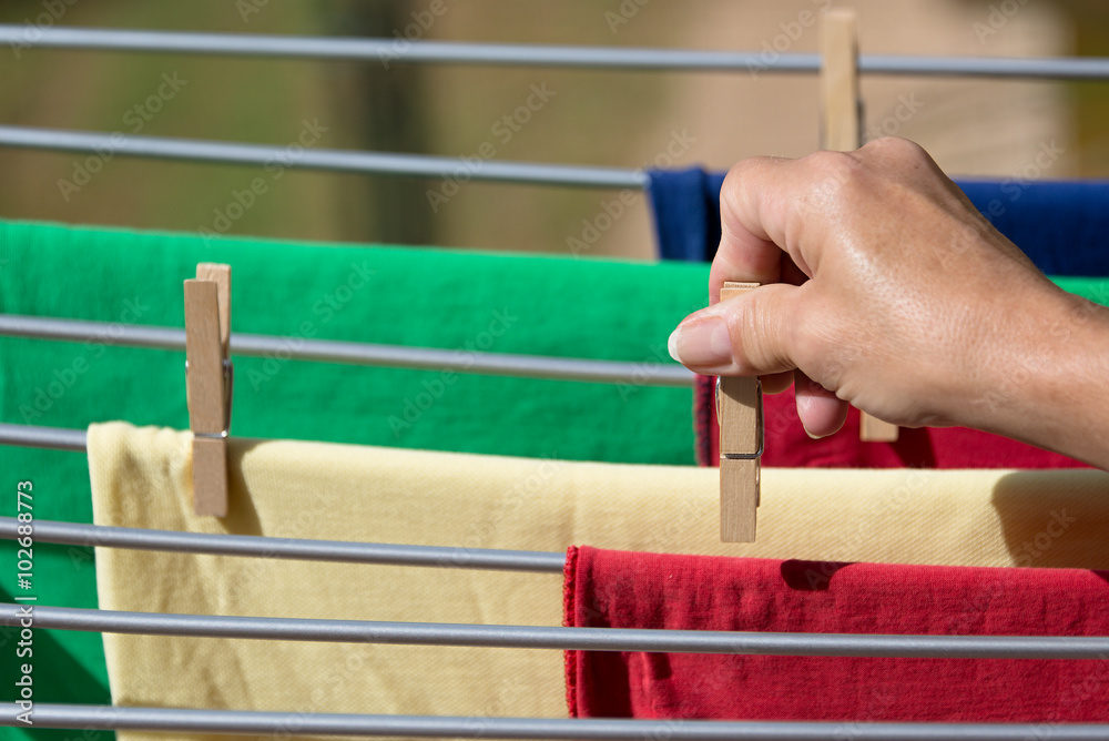 Hands putting T-shirts clothesline to dry