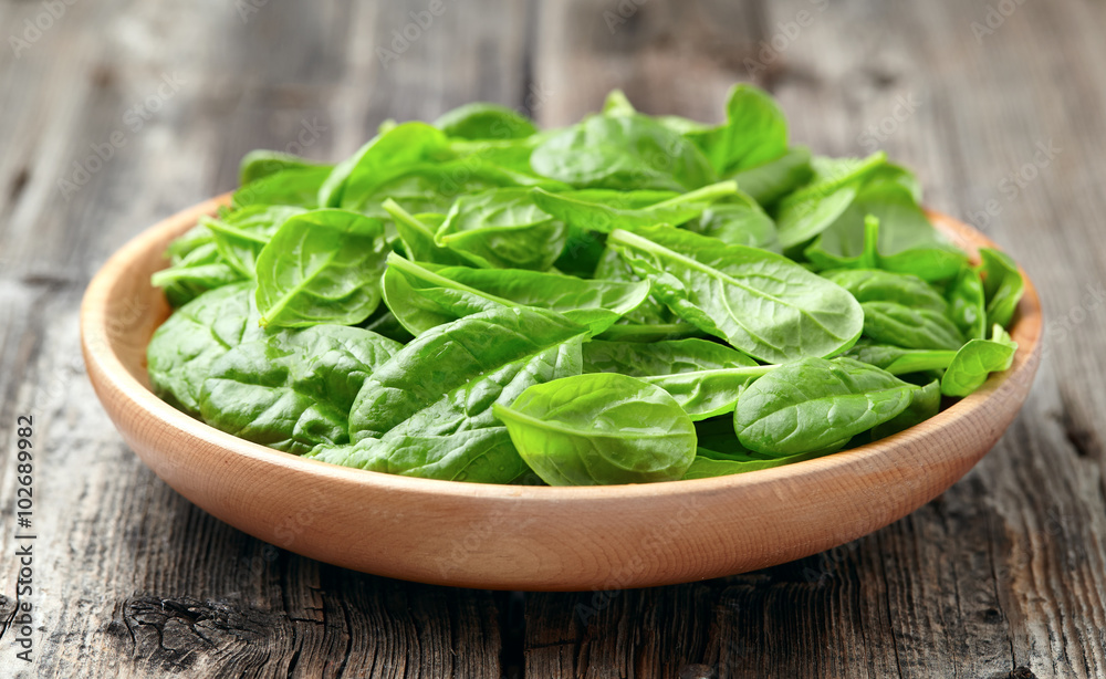 Baby spinach in a wooden plate Baby spinach in a wooden plate