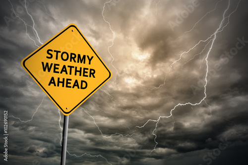 Sign with words 'Stormy weather ahead' and thunderclouds