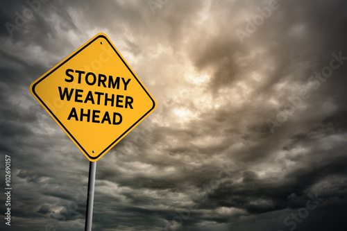 Sign with words 'Stormy weather ahead' and thunderclouds