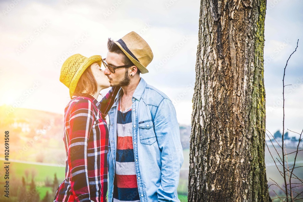 couple of lovers kissing embraced, near a tree in the countryside - lifestyle. people,love and outdoor concept