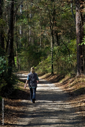 woman walking down a forest path