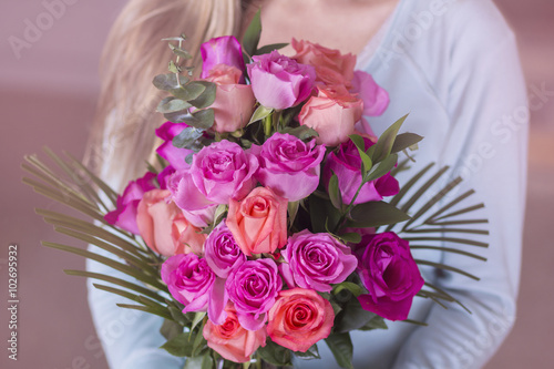 Woman holding a bouquet of beautiful pink roses