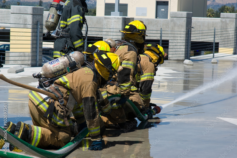Obraz premium Firefighters training for fire with water hose