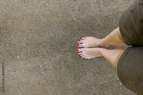 Female feet on the dirt road.