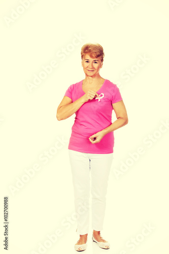 Smiling senior woman with breast cancer awareness ribbon © Piotr Marcinski