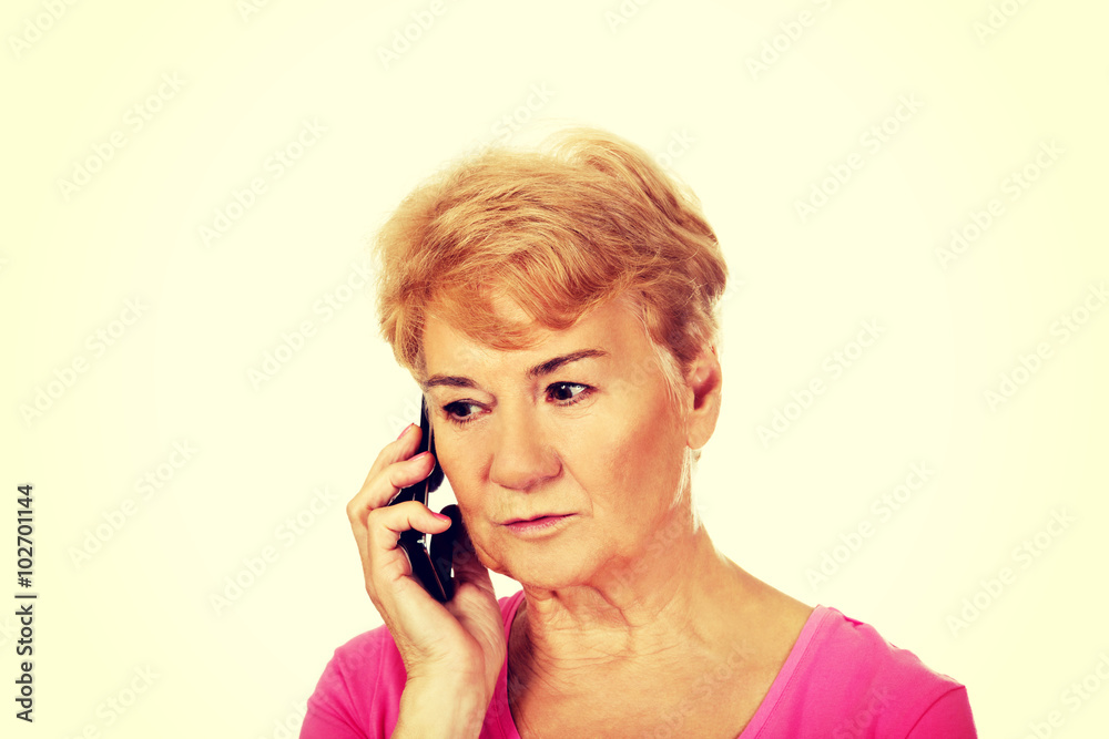 Worried senior woman talking through phone Worried senior woman talking through phone