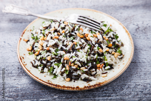 Salad of white and wild rice with pine nuts and herbs.selective focus.