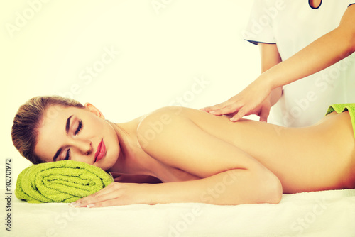 Young relaxed woman lying on a massage table and has massage.