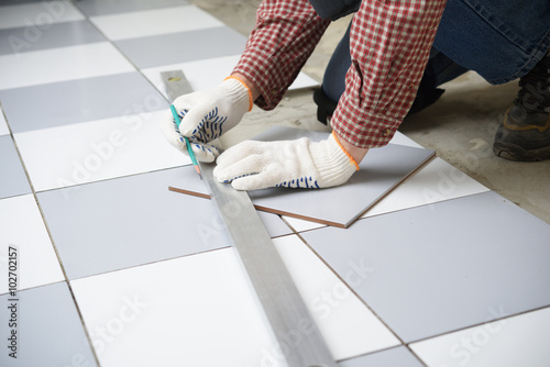 Installing ceramic tiles on a floor photo