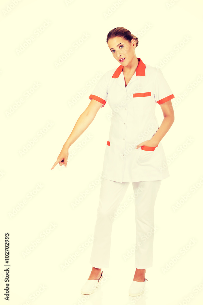 Smiling female doctor or nurse pointing at something Smiling female doctor or nurse pointing at something
