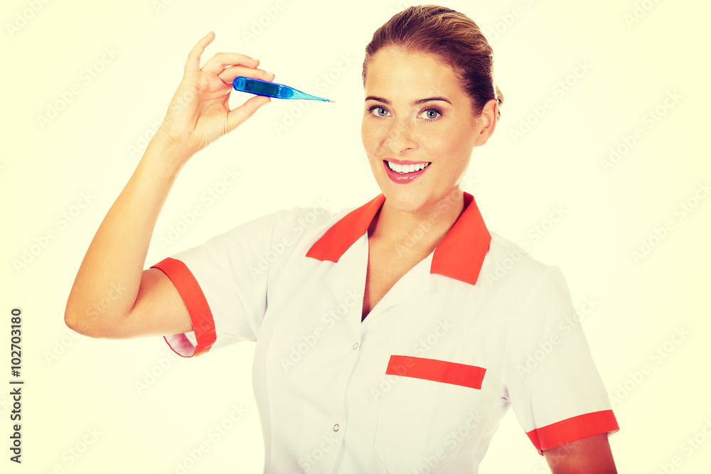 Young female doctor or nurse holding thermometer Young female doctor or nurse holding thermometer