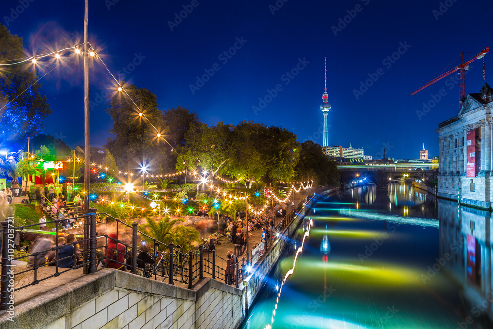 Fototapeta premium Berlin Strandbar przyjęcie przy Spree rzeką z TV wierza przy nocą, Niemcy