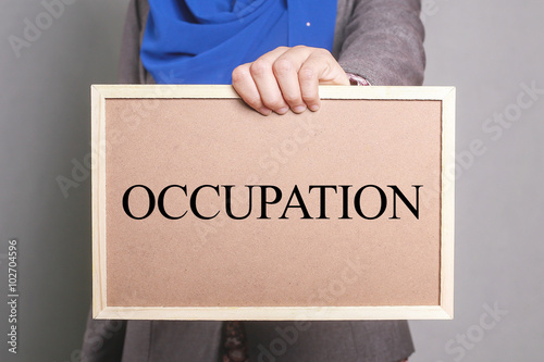 Businesswoman holding a softboard written OCCUPATION photo