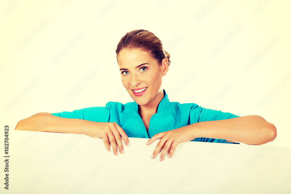 Young female doctor or nurse holding empty banner Young female doctor or nurse holding empty banner