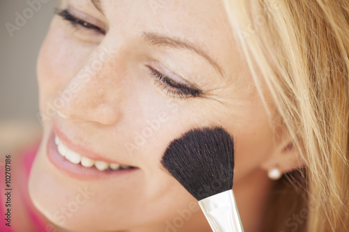 beautiful blonde woman putting on make up 