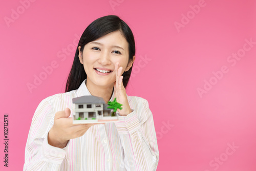 住宅模型を持つ女性