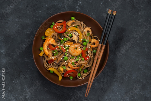 Photography Buckwheat noodles with seafood in a bowl, top view